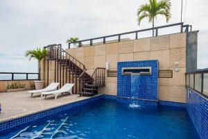 里约热内卢欧神诺科帕卡巴纳酒店的一座带两把椅子的游泳池和一座毗邻大楼的楼梯