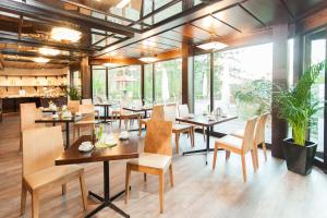 威斯巴登Trip Inn Klee am Park Wiesbaden的餐厅设有桌椅和大窗户。