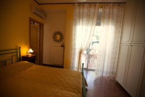 莱波拉诺Phalanthos B&B的一间卧室设有一张床和一个大窗户