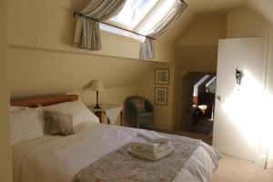 East AnsteyKnapp House Lodges的一间卧室配有一张带天窗的床