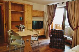 布勒伊-切尔维尼亚Maison Carrel Elegant 12的客厅配有桌椅和电视。