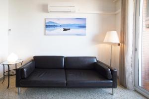 巴塞罗那博德塔公寓的客厅里一张黑色皮沙发,配有灯