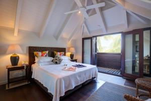 拉罗汤加泰瓦卡罗阿别墅酒店的一间卧室设有一张床和一个大窗户