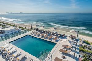 里约热内卢Windsor Marapendi Hotel的享有游泳池和海滩的上方景色