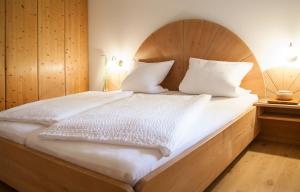 NennslingenFerienwohnungen Grimm的一间卧室配有一张大床和木制床头板