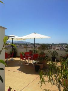 萨各夫雷纳帕洛马勒斯旅馆的屋顶上带桌子和遮阳伞的庭院