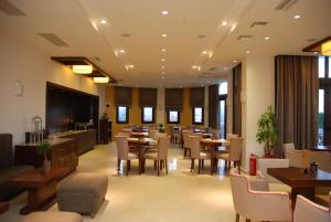 卡托劳塔翁阿迦毗豪华酒店的用餐室设有桌椅和窗户。