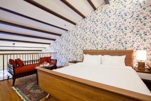 新加坡The Sultan的一间卧室设有一张床和鲜花墙