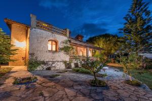 查加基恩Ktima Dikopoulos - Villa Kirstin的石头房子,晚上设有石头庭院