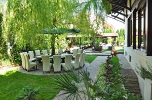 萨图马雷Hotel Vila Class的花园内带桌椅的庭院