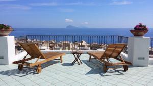 利帕里拉莎嘉拉酒店的阳台上配有两把椅子和一张桌子,享有海景
