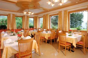 思科纳Garni Pluner的餐厅设有白色的桌椅和窗户。