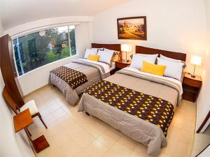 波哥大Hotel Fontanar Usaquen的酒店客房设有两张床和窗户。