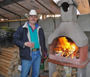 克卢日-纳波卡特兰西瓦尼亚牛仔小屋乡村民宿的站在烤箱旁的牛仔帽上的男人