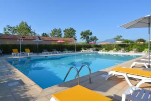 卢恰纳里多酒店的一个带椅子和遮阳伞的大型游泳池