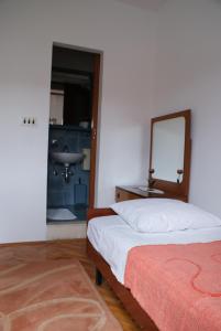 科尔丘拉Korčula Guest House的一间卧室配有一张带镜子和水槽的床