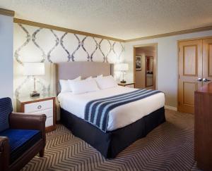 堪萨斯城Harrah's Kansas City Hotel & Casino的配有一张床和一把椅子的酒店客房