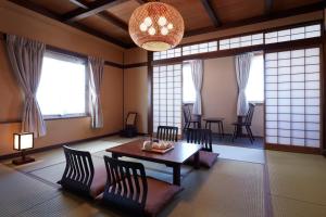 松本松本花月酒店的客厅配有桌椅和窗户。