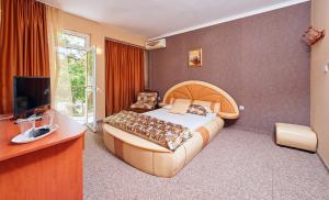 帕莫瑞Peneka Hotel的一间卧室配有一张大床和电视