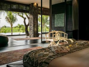 坎古Villa Mana by Elite Havens的一间带大床的卧室和一个带棕榈树的房间