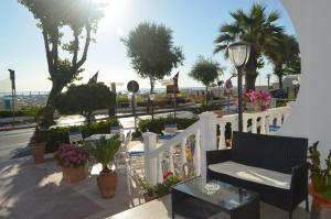 里米尼Hotel Ideal Soleti Hotels的门廊设有白色的围栏、椅子和鲜花