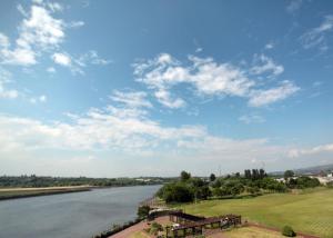 克莱德班克The Golden Jubilee Hotel的享有长椅和云天的河流美景