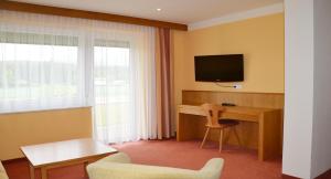 沃尔特湖畔韦尔登范图尔酒店的酒店客房配有书桌和电视。