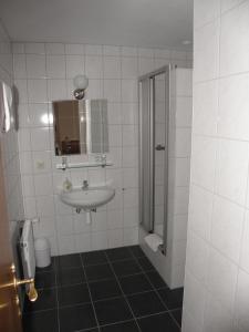 施马伦贝格Gasthof Westfeld的白色的浴室设有水槽和淋浴。