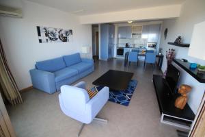 波尔蒂芒Atlantico Apartments的客厅配有蓝色的沙发和桌子