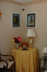圣博内德米尔Le Jardin de Roses DOMINIQUE LOREAU的一张桌子,上面有台灯和花瓶
