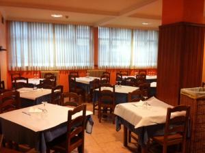 略迪奥巴耶阿亚拉酒店的一间设有白色桌椅和窗户的用餐室