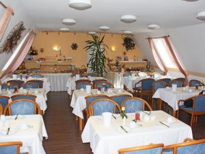 米歇尔施塔特米歇尔城马克公园酒店的一间设有白色桌椅的用餐室