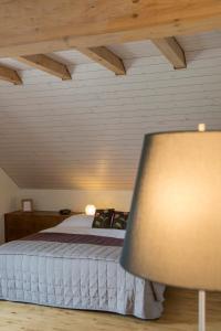 Villarepos白十字旅馆的一间带一张床的卧室,位于带木制天花板的房间内
