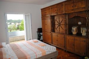 VerunićAnte Carov Apartment的一间卧室配有带时钟的大型木制橱柜