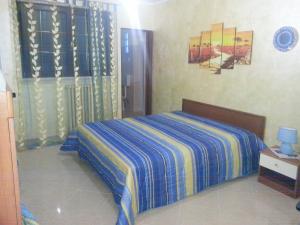 CollepassoB&B La Collina的一间卧室配有一张蓝色和黄色毯子的床