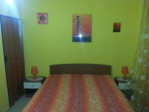 CollepassoB&B La Collina的一间卧室配有一张带绿色墙壁的床和两张桌子