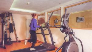 圣维吉利奥Hotel Resa Blancia的站在健身房跑步机上的女人