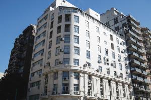 布宜诺斯艾利斯Ker Urquiza Hotel的两座高楼前的白色建筑