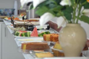 特雷西纳Hotel Ideal的自助餐,包括食物盘和花瓶