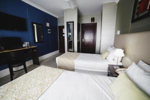 布宜诺斯艾利斯Ker Urquiza Hotel的酒店客房配有两张床和一张书桌