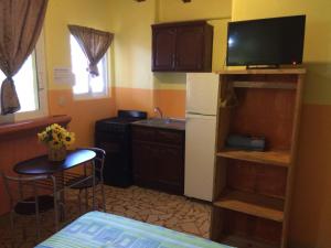 锡瓦塔塔内霍萨利纳斯酒店的小厨房配有小桌子和电视