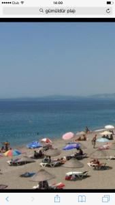 古穆杜尔艾菲斯酒店的一张海滩的照片,上面有遮阳伞和人