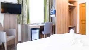 圣卡尼兹马尔科酒店的配有床、椅子和电视的房间