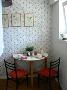 奥斯塔Maison Bibian的桌子,两把椅子,桌子,上面有杯子和盘子