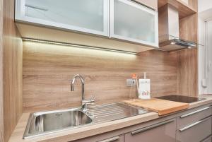 乌马格Apartments Tre Perle的厨房设有不锈钢水槽和木墙