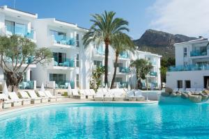 波连萨港MarSenses Puerto Pollensa Hotel & Spa的一座位于酒店前方的白色建筑的游泳池