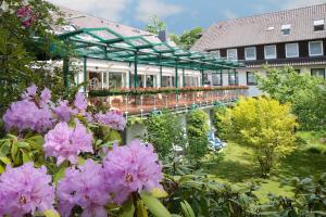巴德贝芬森菲儿豪斯环形酒店的一座花园,在一座建筑前方种有粉红色花卉