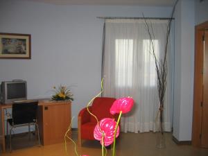 布利亚斯SG酒店的客厅配有红色椅子和书桌