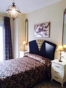 科尼尔-德拉弗龙特拉Hostal Flor De Lis- Lojo的一间卧室配有一张床、两盏灯和吊灯。