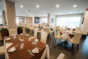 巴亚多米吉亚BNS Hotel Francisco的用餐室配有桌子和白色椅子